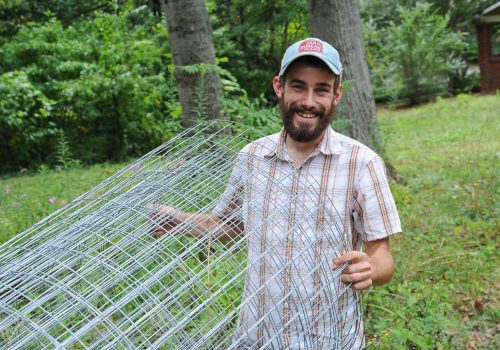 Man holding wire fencing